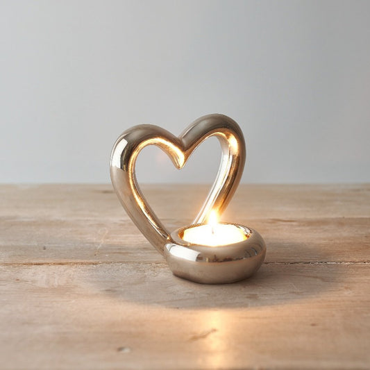 A sleek and simple ceramic tlight holder with a small heart cut decal to complete its look   A charming accessory to bring to any home space
