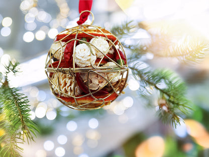 Decorative Christmas ball ornament on a tree with blurred lights in the background